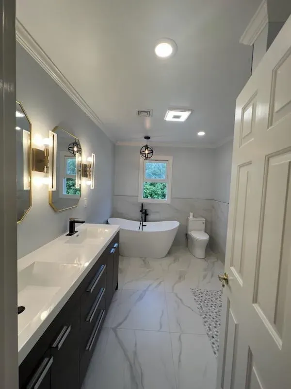 Modern bathroom with marble flooring and freestanding tub.