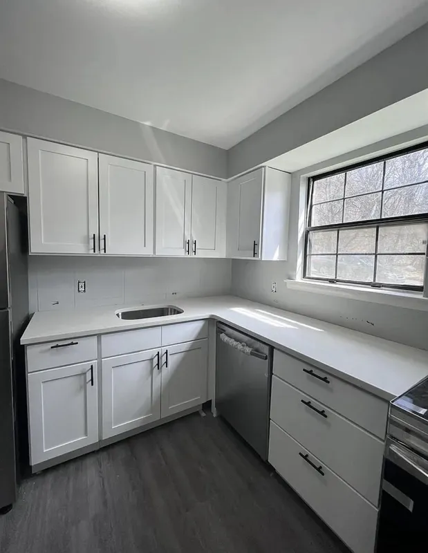 New kitchen renovation with white shaker cabinets and quartz countertops.